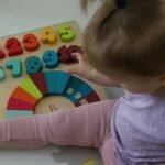 a little girl playing with a wooden toy